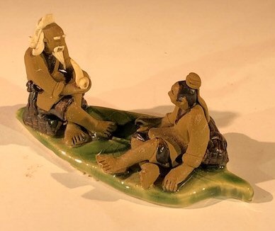 Miniature Ceramic Figurine Two Mud Men On A Leaf, One Sitting Smoking A Pipe, The Other Sitting - 2"